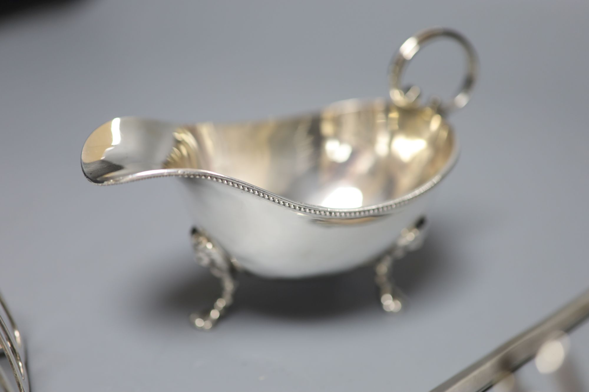 A George III silver meat skewer, Smith & Fearn, London, 1793, a silver sauce boat and a pair of silver toast racks, 9oz.